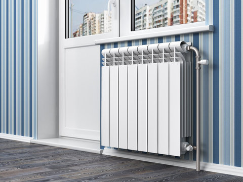 White radiator with thermostat in the apartment