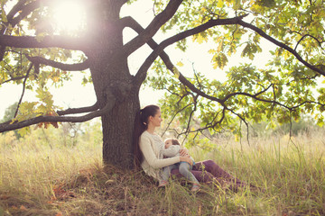 Mother and toddler girl have rest outdoors