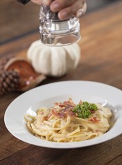 sprinkle spices on spaghetti Carbonara
