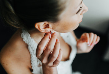 Bride puts on earrings