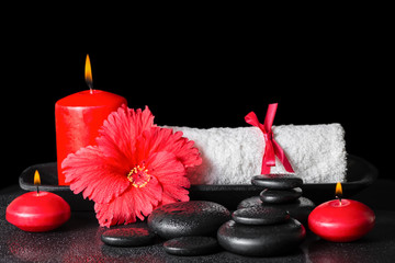 beautiful spa concept of red hibiscus flower with dew, candles a