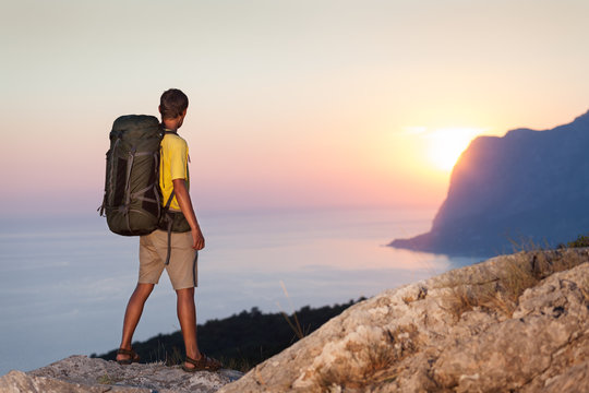 Man with backpack and looking at sunrise