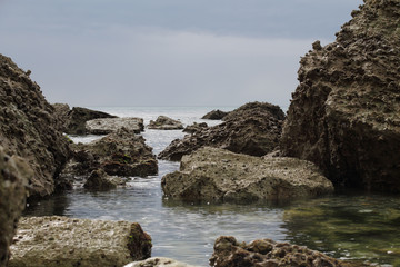 Fototapeta na wymiar sous un ciel orageux, des rochers affleurent à marée basse