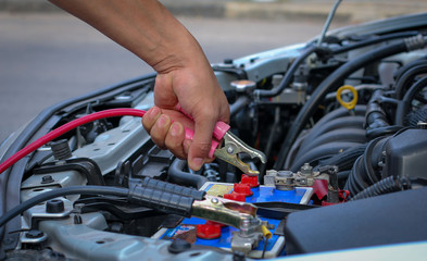 Jumper cables charging battery on a car