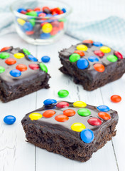 Homemade brownies with chocolate ganache and colorful candies
