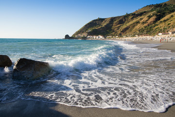 the waves breaking on the deserted beach, the background blue sk