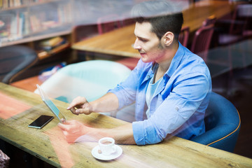Man using digital tablet at cafe
