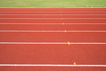 red running track with green grass