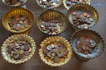 donate Thai coins on old tray