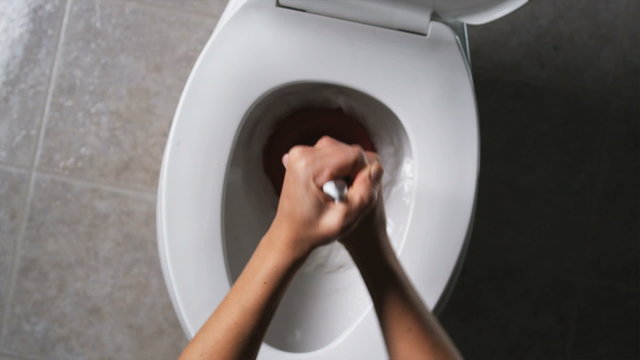 hands plunging a toilet