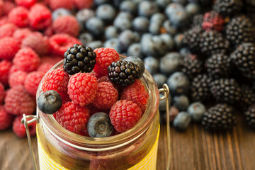 different berries in a basket on a wooden table