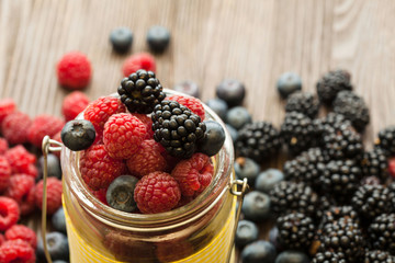 different berries in a basket on a wooden table