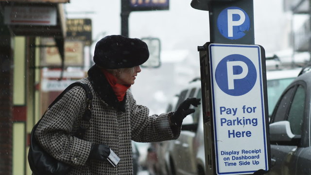 woman paying for parking at an automated parking machine