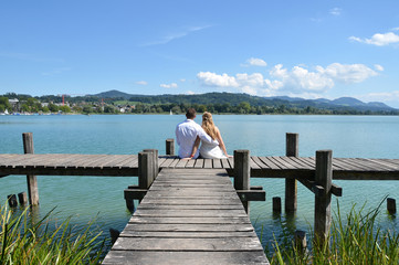 A couple on the wooden jetty at the lake. Switzerland