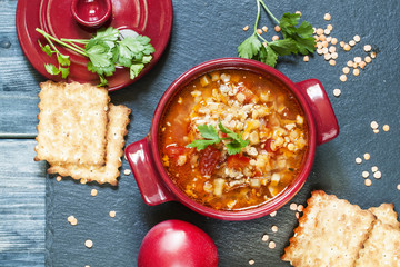 Tomato soup with red lentils and minced meat in a saucepan of se