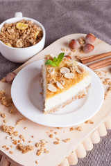 piece of cheesecake with nut on wooden board