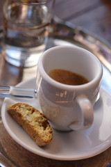 A cup of espresso with cantuccini and a glass of water
