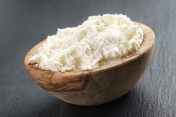 creamy cheese in wooden bowl