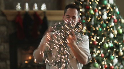 man untangling Christmas tree lights - Powered by Adobe