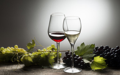 glasses of wine with grapes on the wooden table