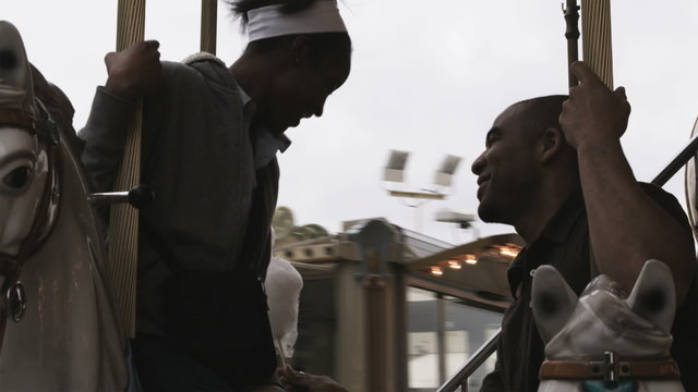 couple on a carousel next to the Eiffel tower eating cotton candy