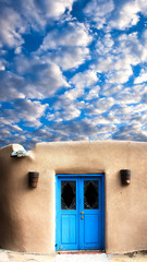 Obraz premium Adobe Building with a Blue Front Door