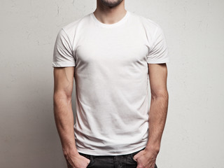Fototapeta premium blank white t-shirt on muscle young man with stubble and grunge cracked wall background