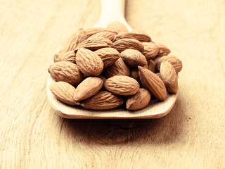 Almonds on wooden spoon