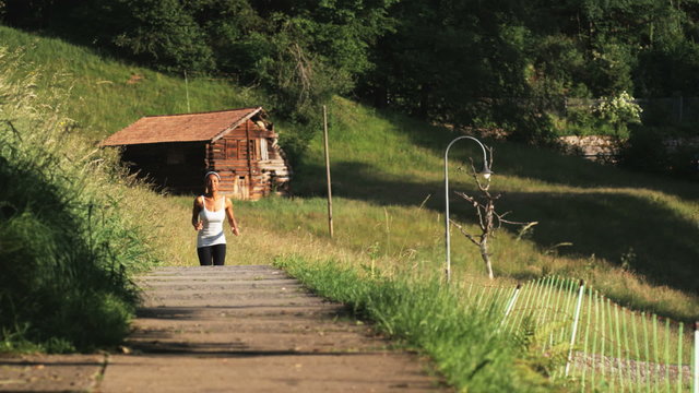 woman running along an alpine trail