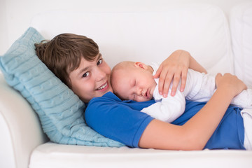 Boy holding his newborn baby brother