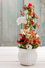 Floral arrangement with ranunculus, orchid and carnation flowers
