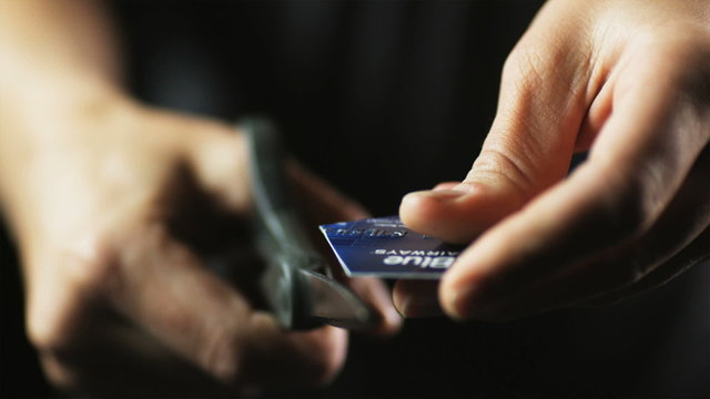 CU Woman cutting credit card into pieces.