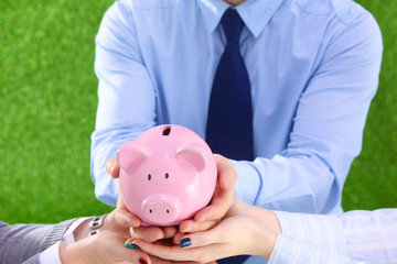 Group of business people saving money on the piggy bank