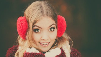 Portrait of pretty smiling woman in red earmuffs.