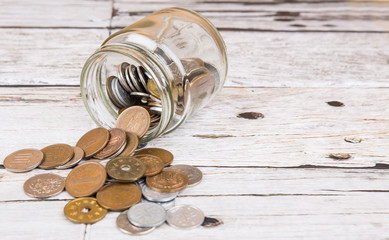 Japanese Yen coins in a mason jar over wooden background
