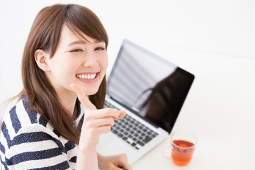 部屋でパソコンを使う女性