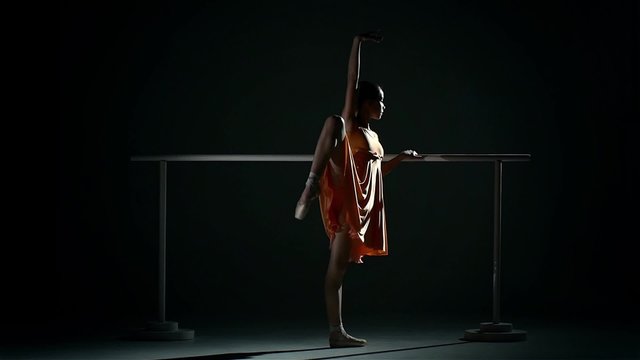 ballerina in the ballet hall on black. slow motion