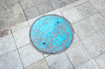 Blue manhold cover on street