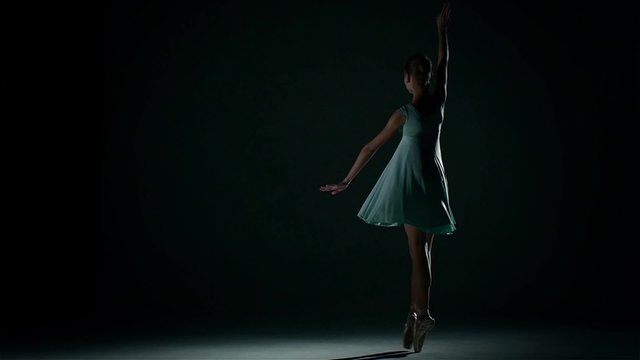 girl dances in a pretty blue dress on a dark background