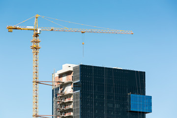 construction site with cranes against blue sky