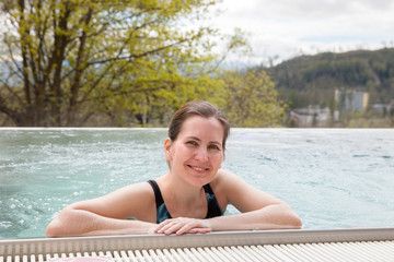 The woman is swimming in outdoor pool in spring day, Tatranska Lomnica, Slovakia