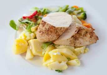 Roasted chicken with boiled potato on white plate