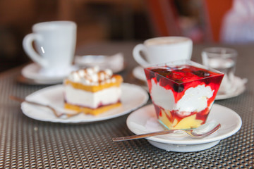 Two desserts stand on table in cafe