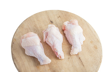 raw chicken legs on wooden cutting boards on white background