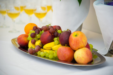 Fruit on a platter. Festive table with food. Serving. Bananas, grapes and pears and apples.