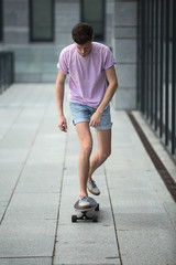 Stylish teenager riding a longboard 
