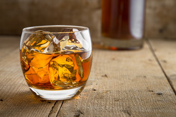 Bourbon brandy and bottle delicious tasty glass on ice classic modern rustic bar table bar saloon barrel