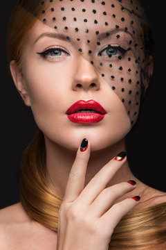 Beautiful girl with a veil, evening makeup, black and red nails