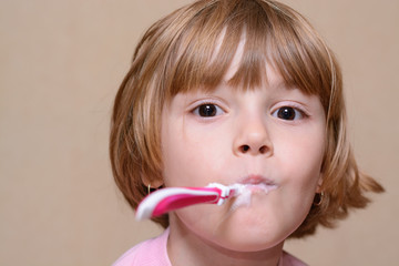 Girl brushing her teeth with a toothbrush