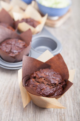 Flourless chocolate courgette muffins in a muffin tin, on a wooden table